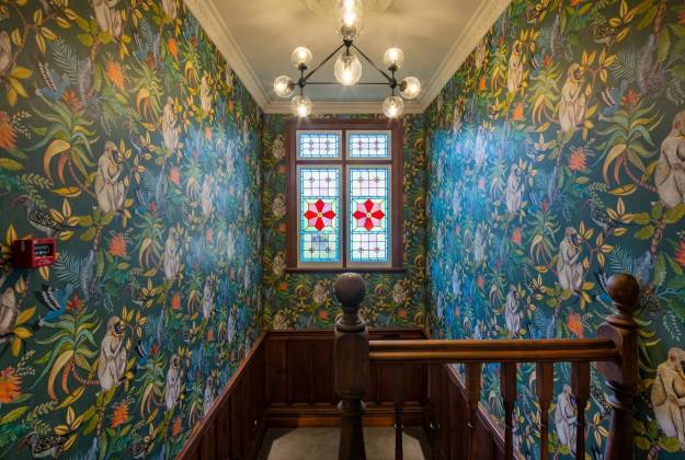 Stairway with wallpaper and stained glass window at The Vicarage Geraldine luxury hotel accommodation